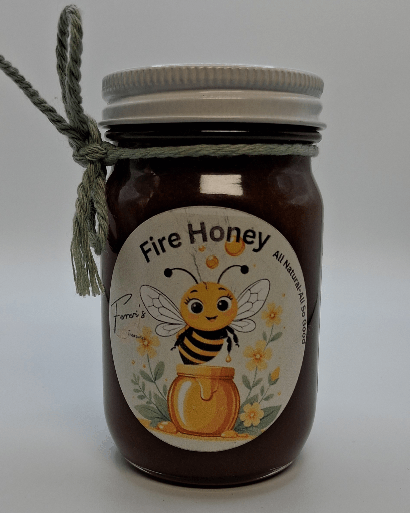 A jar of Fire Honey with a decorative label featuring a cartoon bee and floral elements, tied with a green twine.